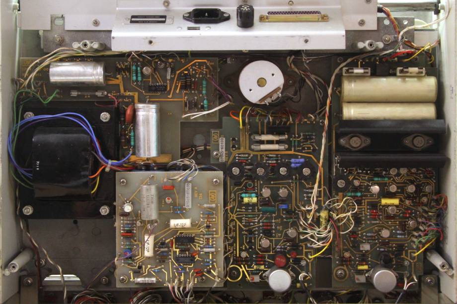 Der HP 7045A, von unten gesehen, nachdem der Boden entfernt wurde. Einige Platinen sind zu sehen, alle mit handgezeichneten vergoldeten Leiterbahnen und mit THT-Bauteilen bestückt.